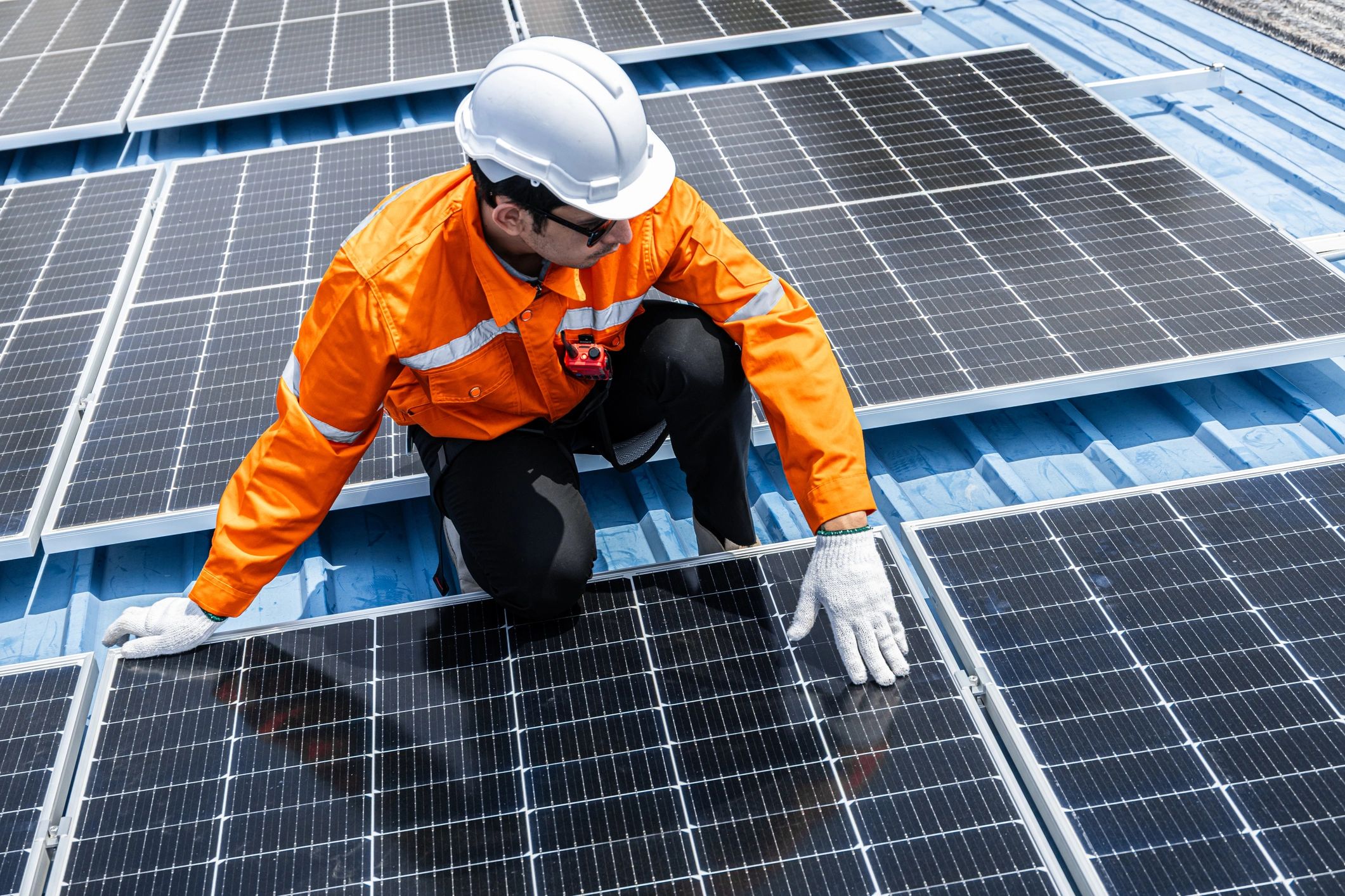 Technician cleaning rooftop solar panels